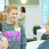 three alumni talking together